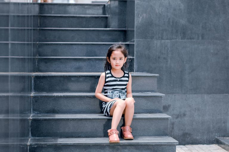 Young girls sitting on some outdoor steps.
